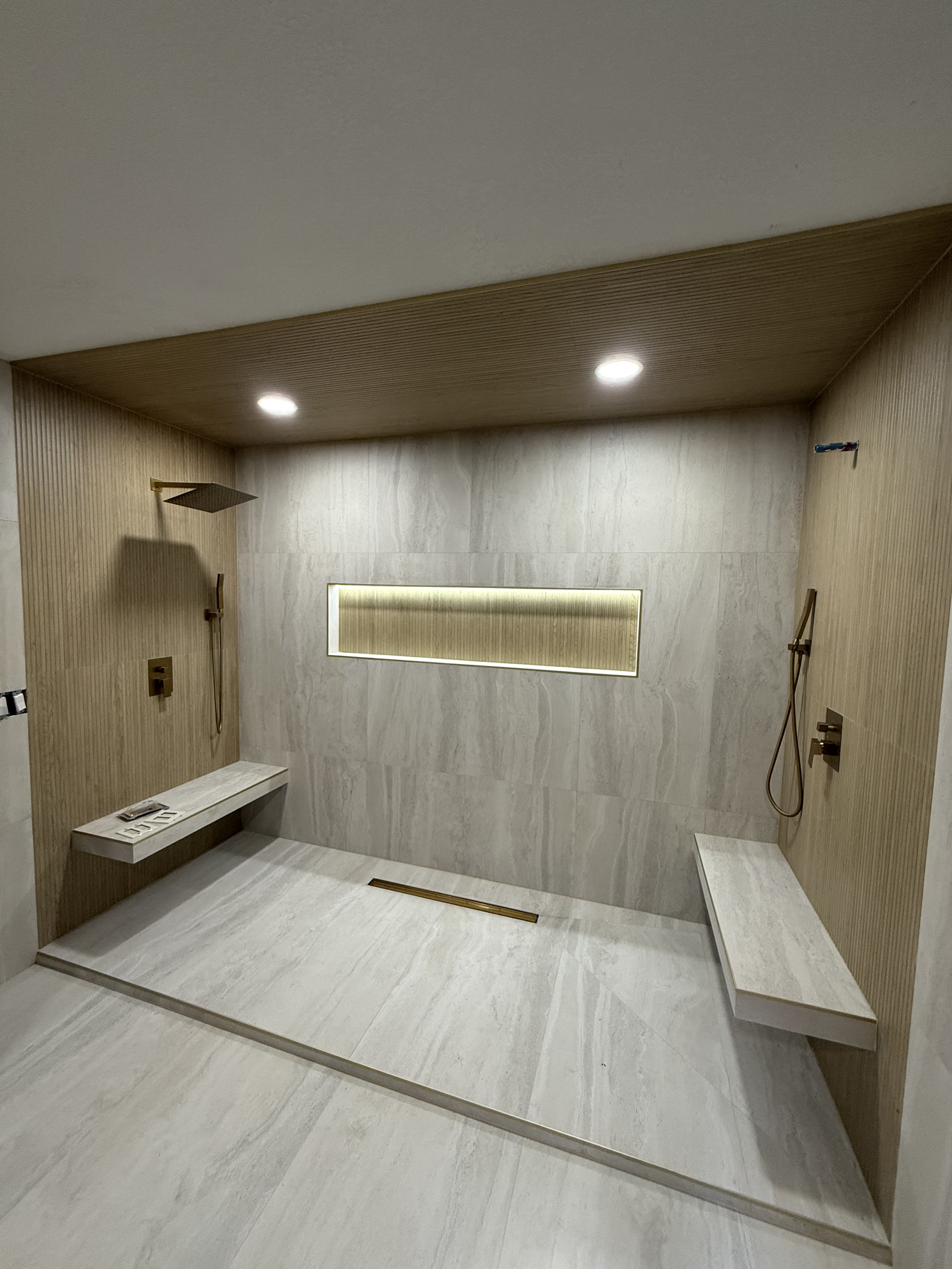 Spa-style shower with wood accents and gold drain